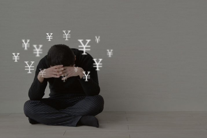 A man is troubled and holding his head in his hands.